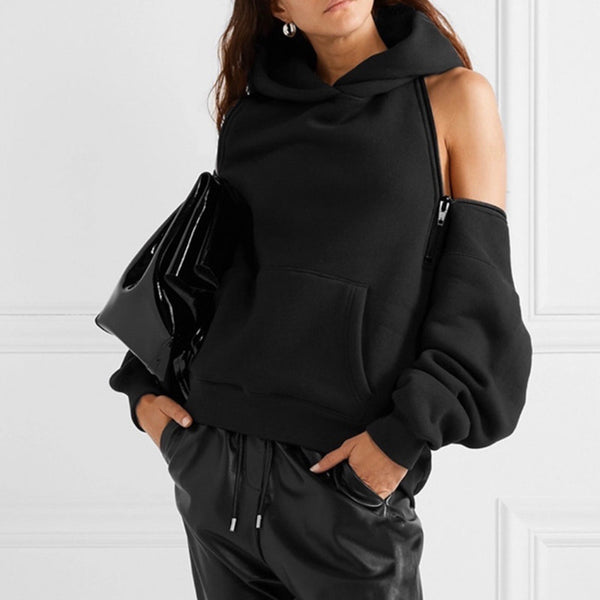 oversized black womens hoodie streetwear inspired with off shoulder and back zippers on model with black leather trousers